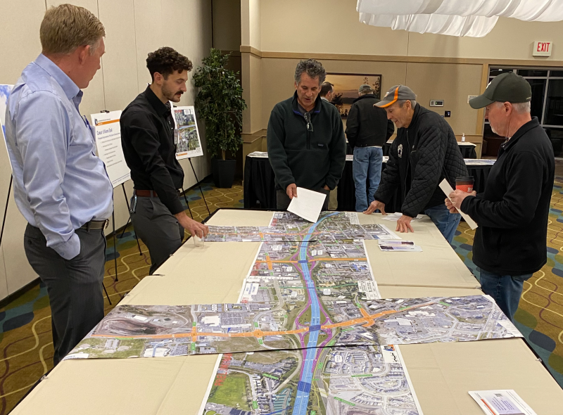 Community members gathered around a map of the proposed design at a recent public meeting.