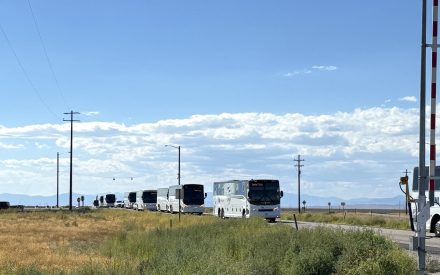 Idaho National Laboratory buses drive east on US-20.