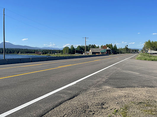 US-20 roadway and access to a local business in Last Chance near the Henry's Fork of the Snake River in the Island Park corridor, Idaho.