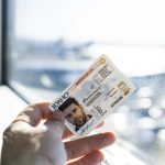 A person is standing next to a window with their Star Card in hand. The camera is zoomed in on the hand holding the card.