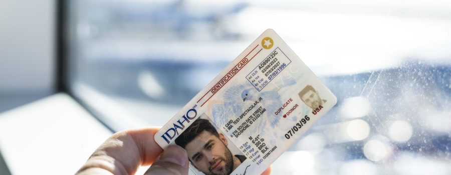 A person is standing next to a window with their Star Card in hand. The camera is zoomed in on the hand holding the card.