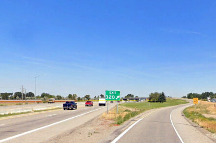 US-20 Exit 320 off ramp into Rigby, Idaho as traffic moves on roadway.