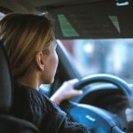 Blonde woman driving car, she is sober and attentive.