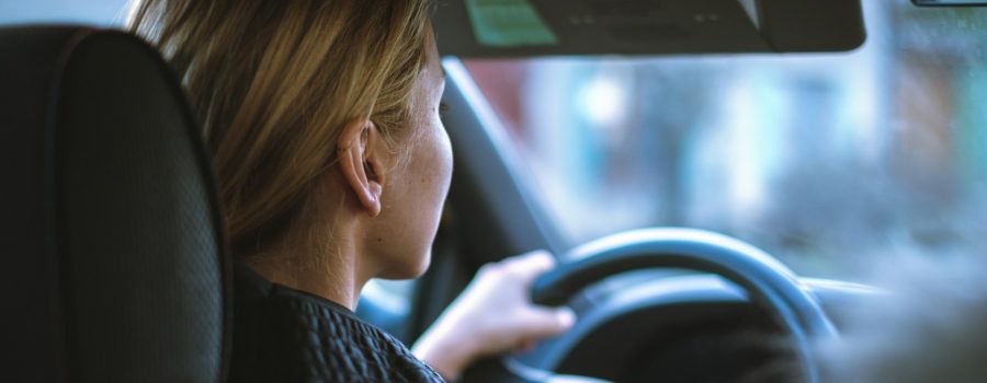Blonde woman driving car, she is sober and attentive.