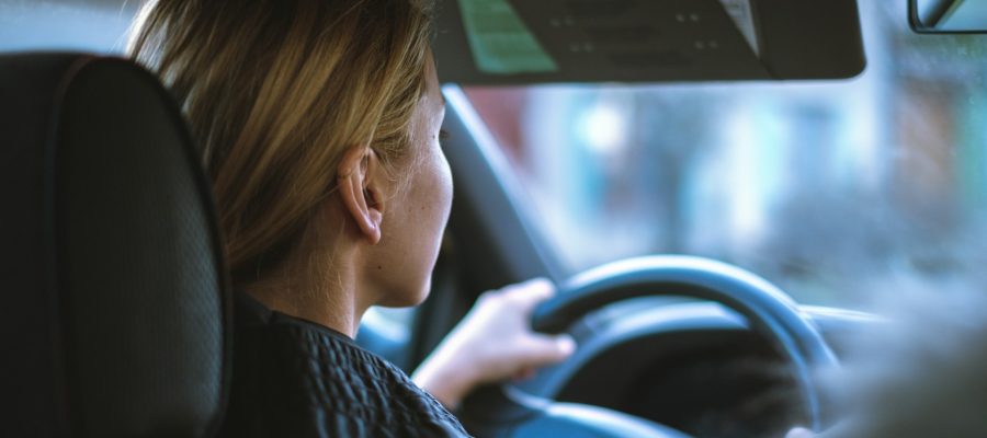 Blonde woman driving car, she is sober and attentive.