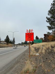 Orange sign along I-90 advising drivers of variable speed limits ahead.