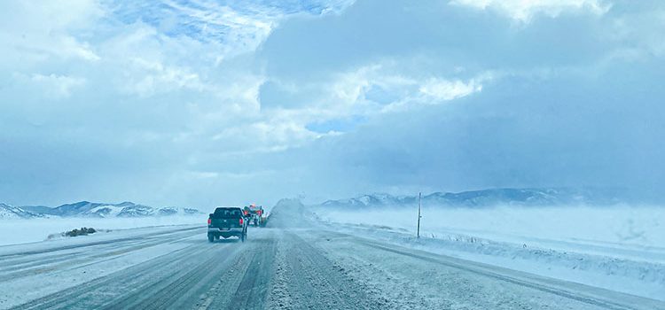 PR East Idaho Free Winter Driving classes roadside view of icy road with a pickup and snowplow in the distance