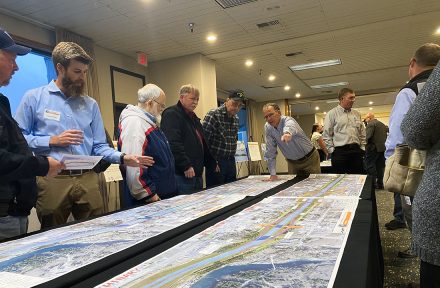 People review maps at a public meeting