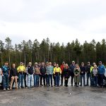 A large group of Operations employees from ITD and MDT between vehicle with both state logos on them.