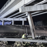 A police officer stands below a pilar hanging loose from the overpass.