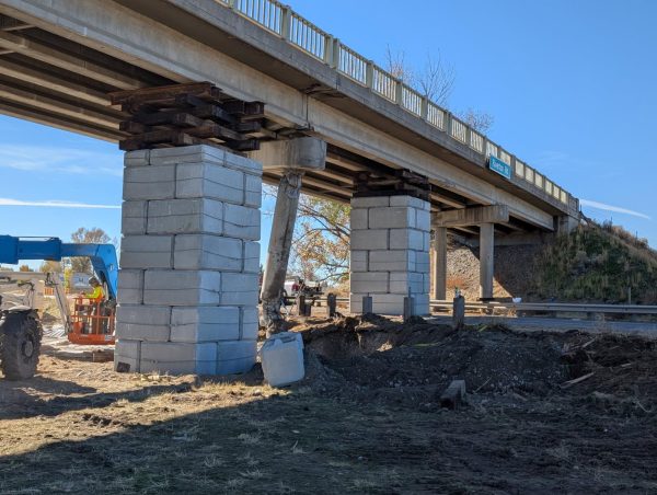 Two large columns of concrete blocks support the bridge on either side of the damaged pillar.