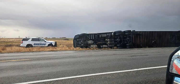 A semi on it's side over a roadway in Idaho as a result of a severe storm. Law enforcement and ITD vehicles in the scene as well.