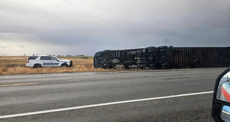 A semi on it's side over a roadway in Idaho as a result of a severe storm. Law enforcement and ITD vehicles in the scene as well.