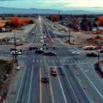 Aerial view of the State Highway 16 and State Highway 44 intersection showing heavy traffic, temporary signals, and active construction. Earthwork and construction equipment are visible around the intersection.