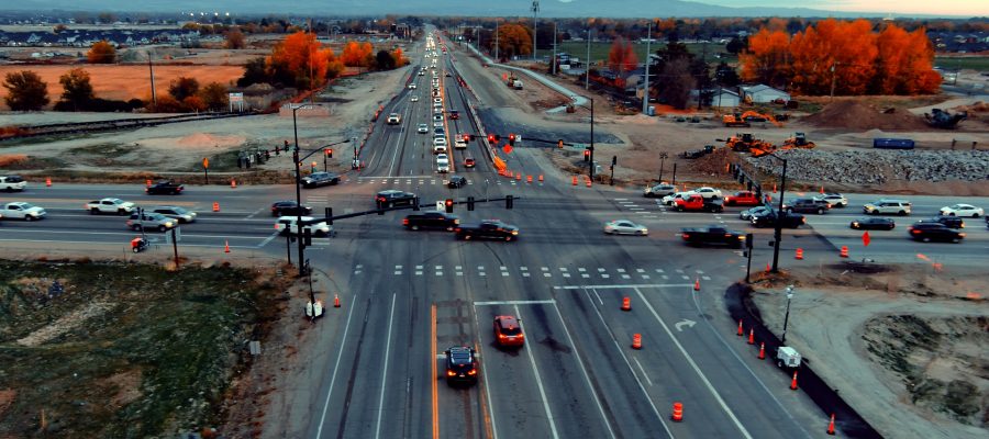 Aerial view of the State Highway 16 and State Highway 44 intersection showing heavy traffic, temporary signals, and active construction. Earthwork and construction equipment are visible around the intersection.