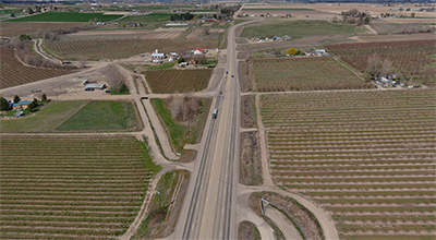 Aerial of SH-55 facing north which travels through farmland on both sides with a scattering of houses in the distance.