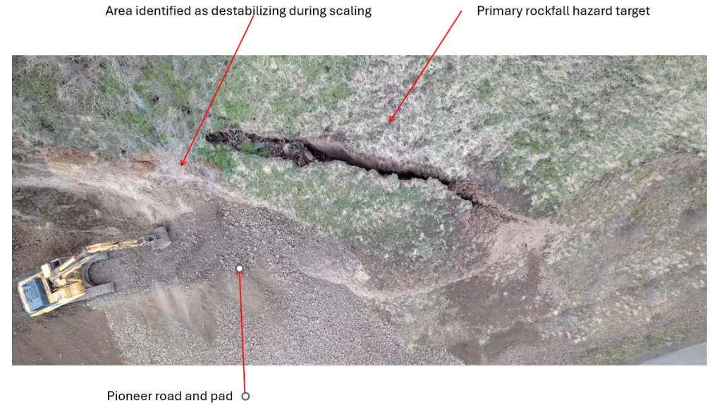 Excavator parked while crack in highwall is assessed.