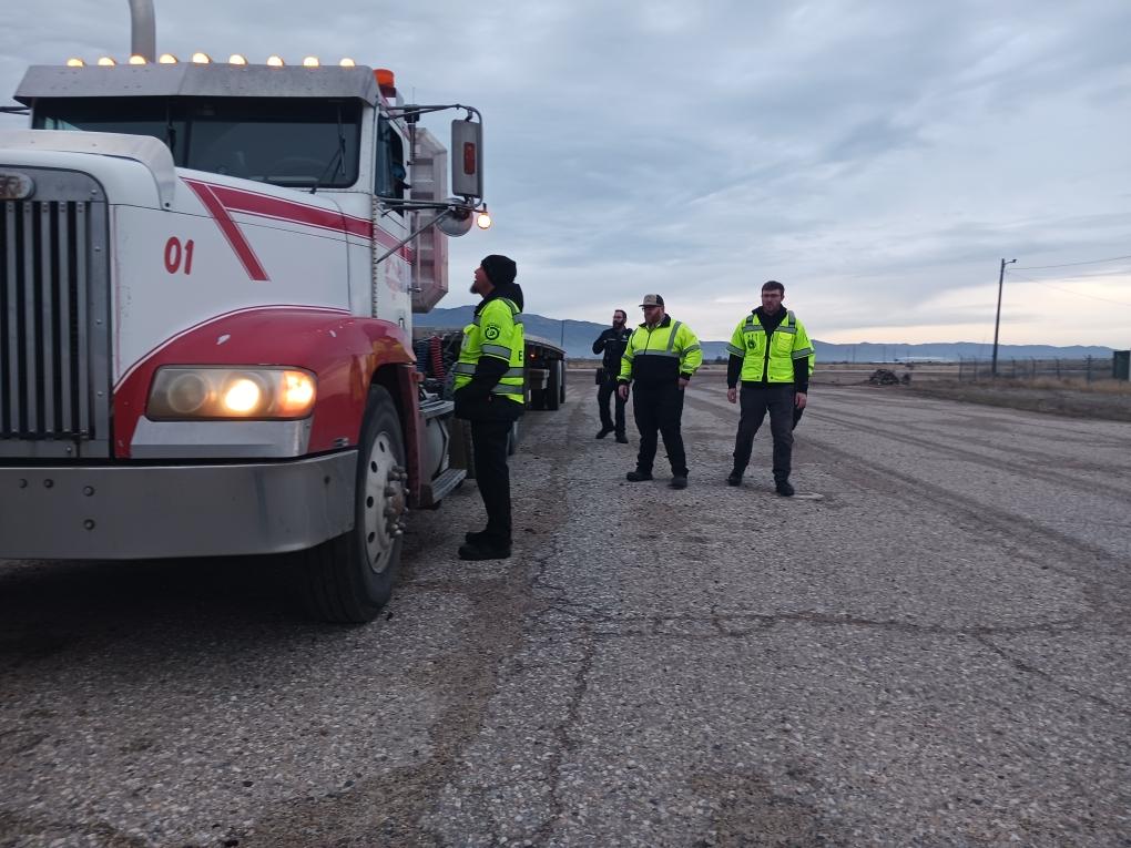 ITD employees speaking with a truck driver positioned behind the wheel of his truck at a Port of Entry.