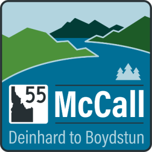 Graphic sign for Idaho Highway 55 showing a river flowing between mountains and trees, labeled ‘55 McCall’ with the subtitle ‘Deinhard to Boydstun.