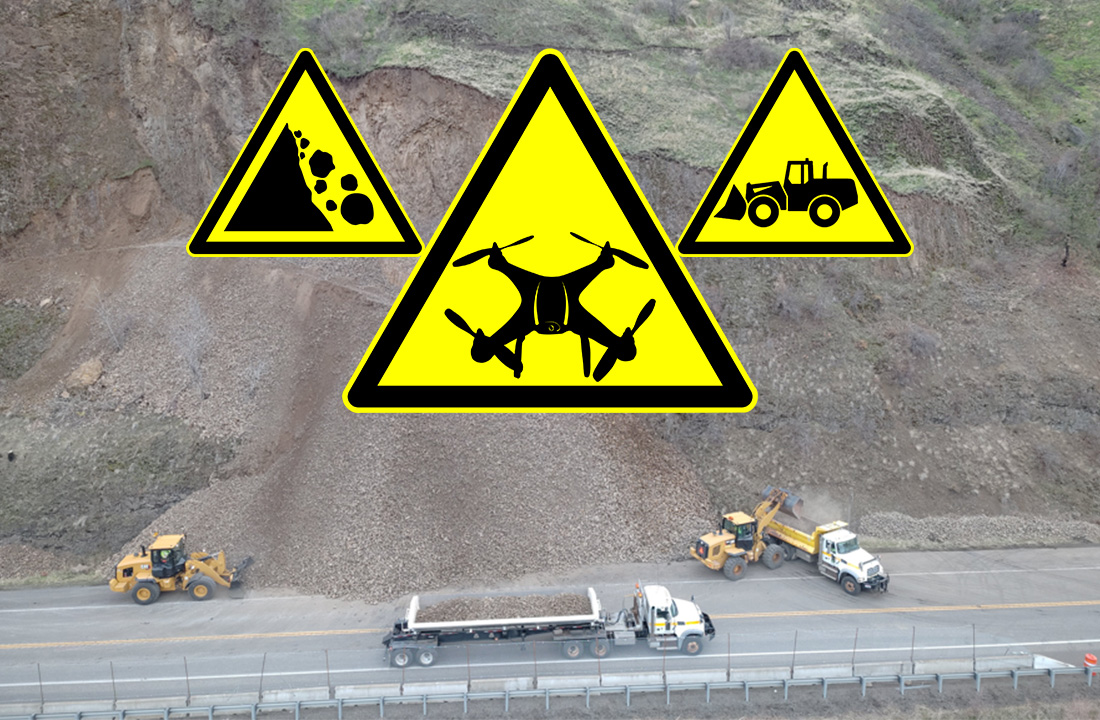 Drone image of the US-12 emergency rock scaling project near Arrow Bridge in District 2. Three yellow construction icons can be seen in the center of the background. The icon on the left is a slope with falling rocks, the icon in the center is a drone and the last one on the right is a loader.