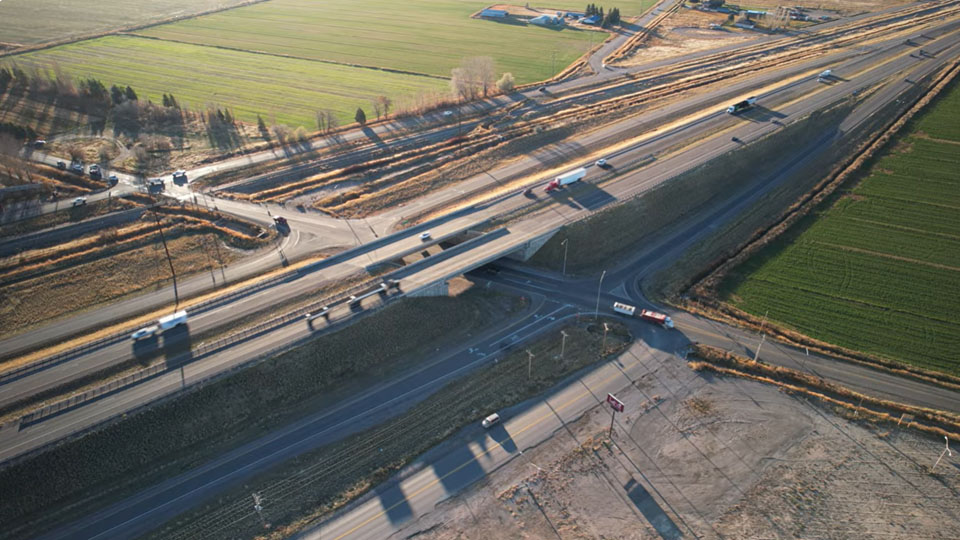 Aerial view of US-20 County Line Road exit near Rigby, Idaho, during morning travel time.