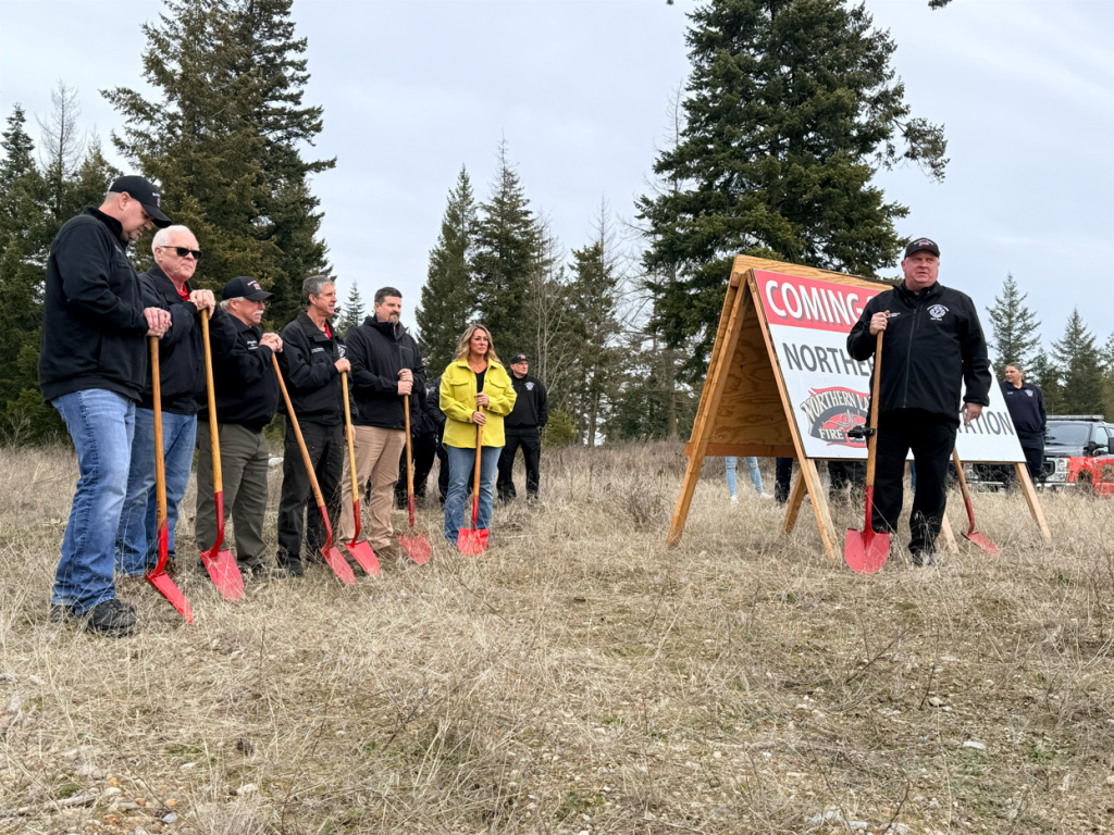 Fire personnel and ITD staff stand with shovel looking on as the Fire Chief gives a speech ahead of the groundbreaking ceremony.