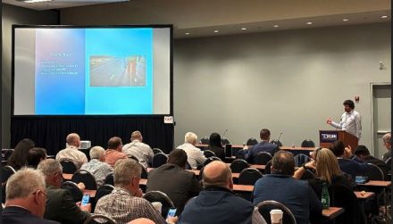 ITD's Mike Copeland stands at lecturn to speak to a room full of people.