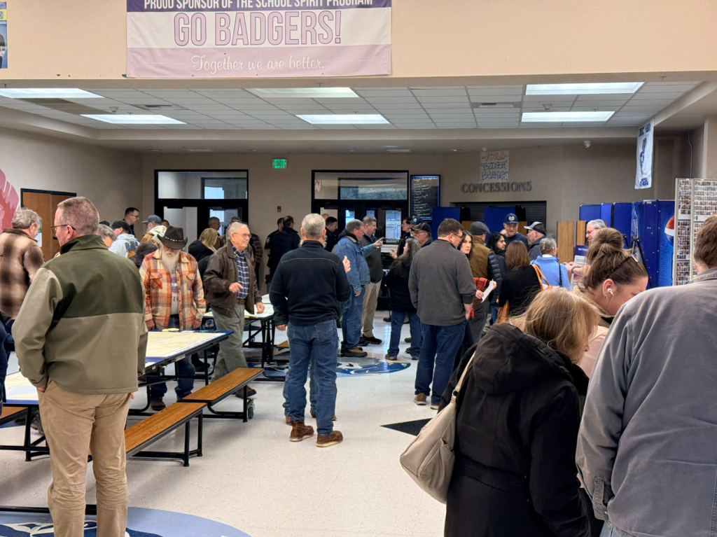 Attendees reviewing displays and table maps at the US-95 Corridor Safety Workshop.