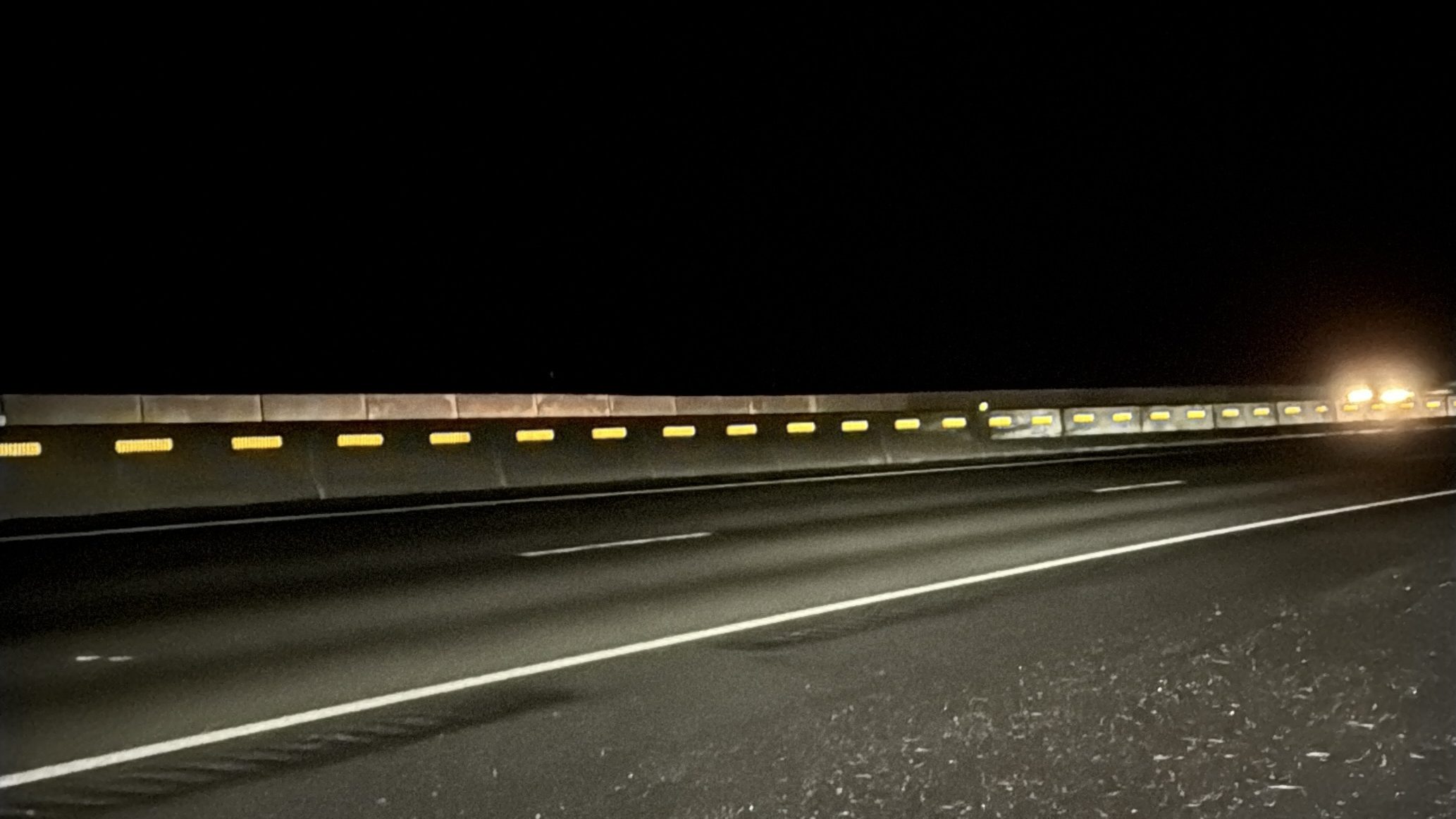 The roadway at night with upgraded reflective barriers making it much easier for drivers to see.