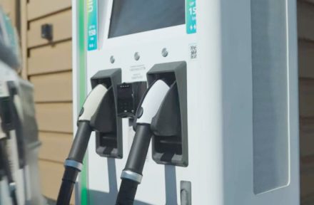 Close-up of an electric vehicle charging station with two charging connectors docked in their ports