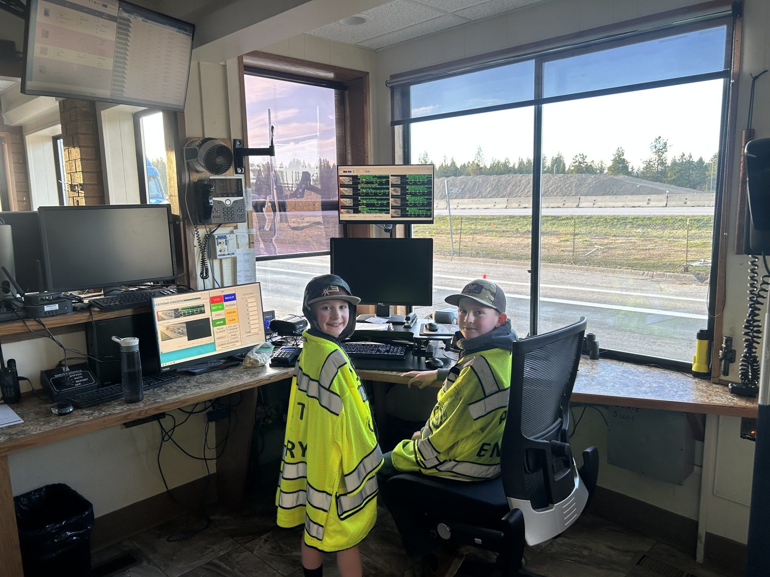 Two young boys with yellow vests sit inside the POE and smile at the camera.