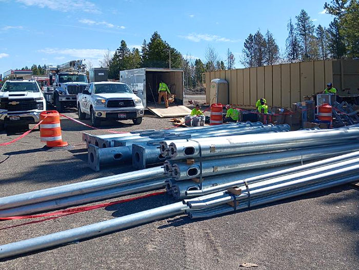 Traffic signal poles staged on the ground during installation along US-20 in the Island Park area.
