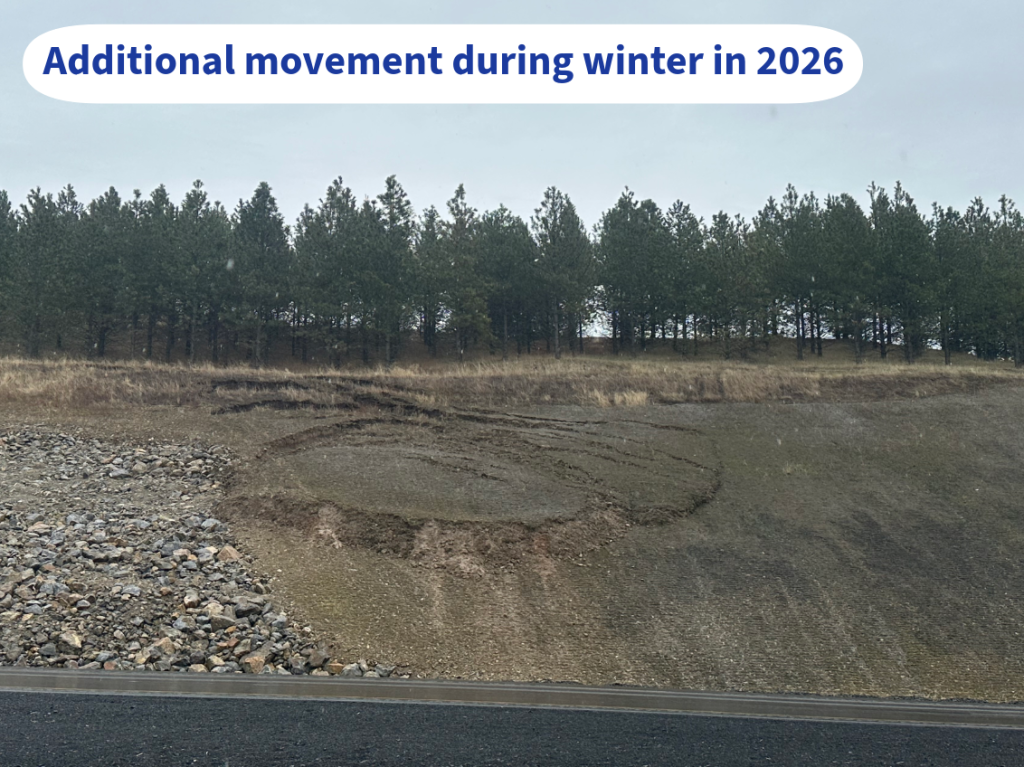 A slope beside U.S. Highway 95 shows additional soil movement and erosion following winter weather in 2026, with visible cracking and displacement near a previously repaired area.