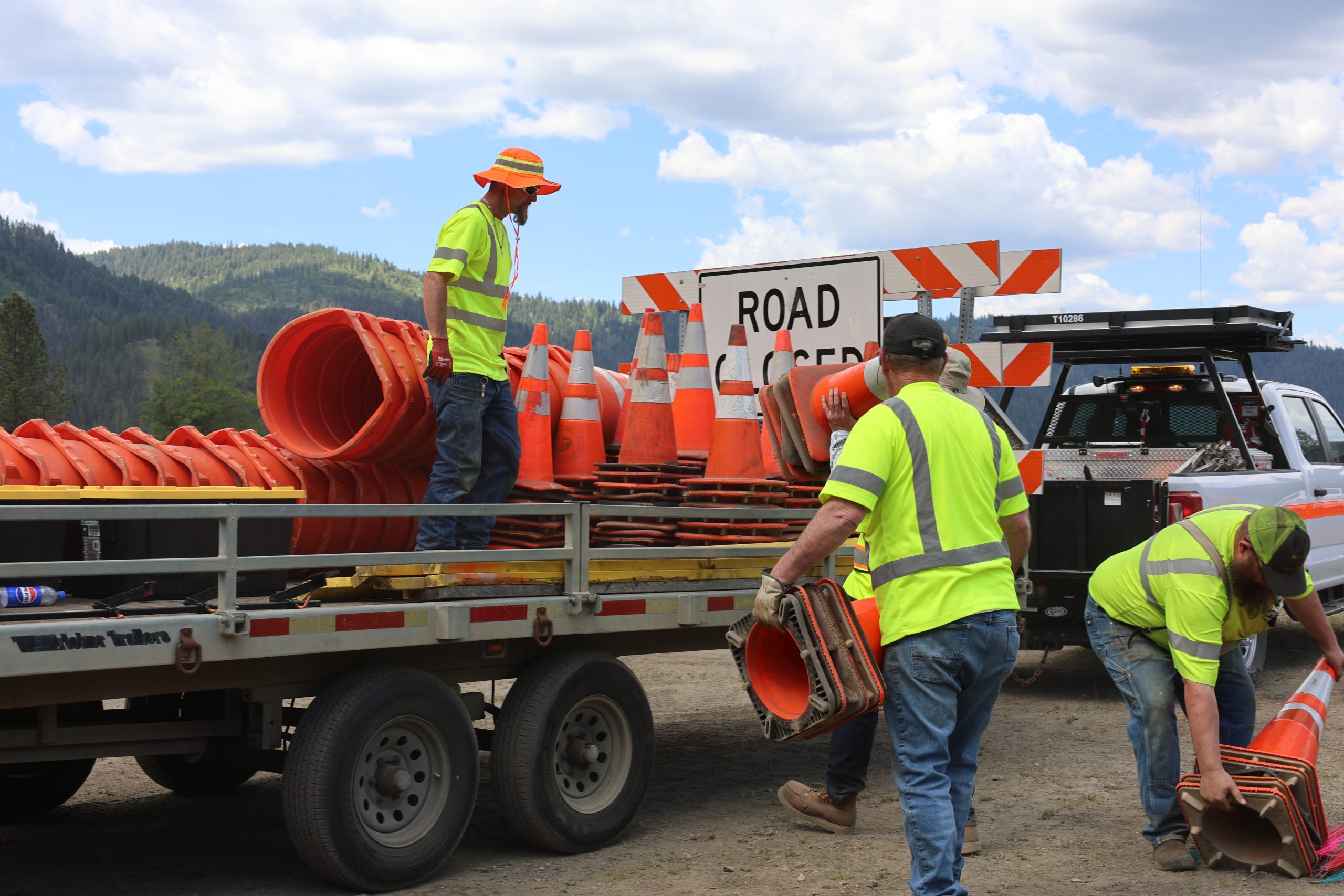 Idaho Transportation Department employees load traffic cones, barricades and work zone equipment onto trailers in preparation for roadway construction.