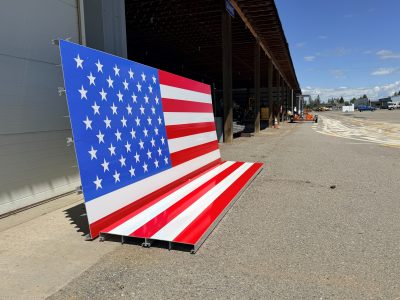 Two large pieces that make up an American flag display sign, ready for installation.