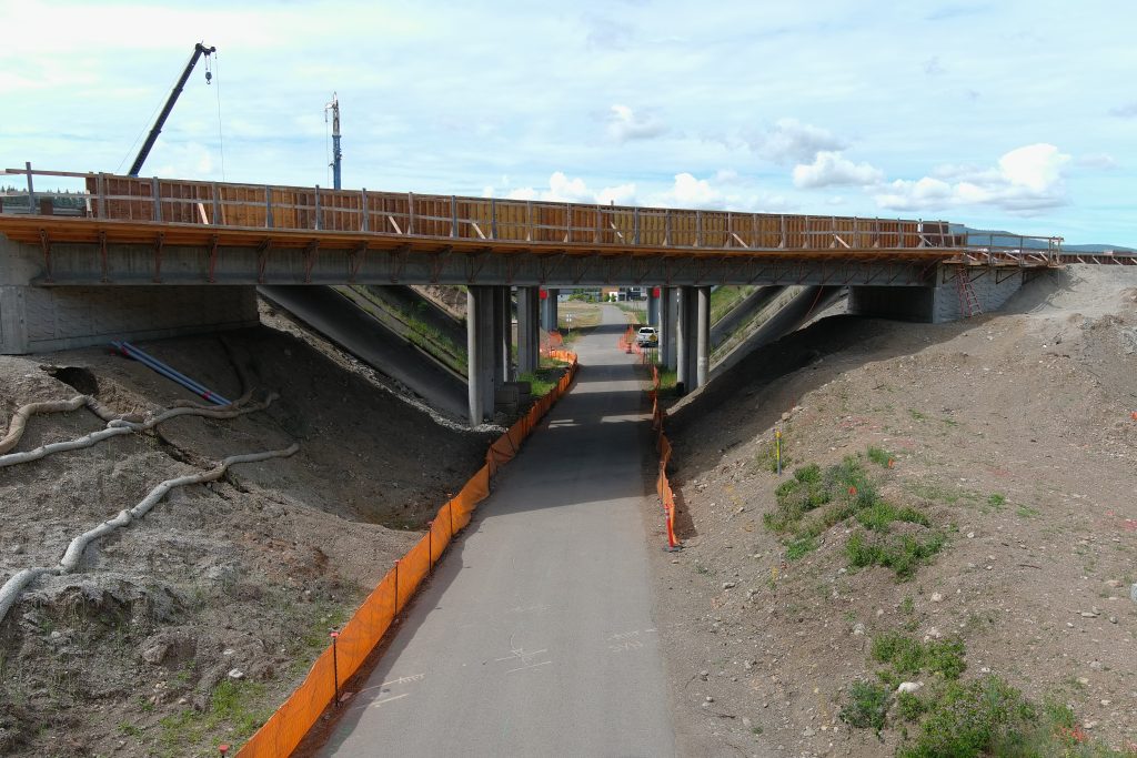 A multi-use pathway extends beneath an interstate bridge. 
