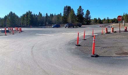 Intersection of US-20 and Yale-Kilgore Road in Island Park, Idaho, showing work zone traffic cones in place.