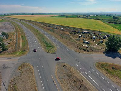 Aerial view of US-20 and 7th East at-grade intersection north of Sugar City, Idaho, showing asphalt median that will be removed and the crossing permanently closed.