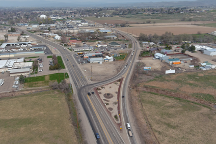 Aerial view of the Y intersection on US-95 in Payette, with traffic moving through the split roadway near nearby businesses, fields and industrial buildings.