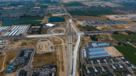 Aerial view of the State Highway 16 and State Highway 44 Interchange under construction, with new roadway connections surrounded by homes, businesses, farmland and ponds.