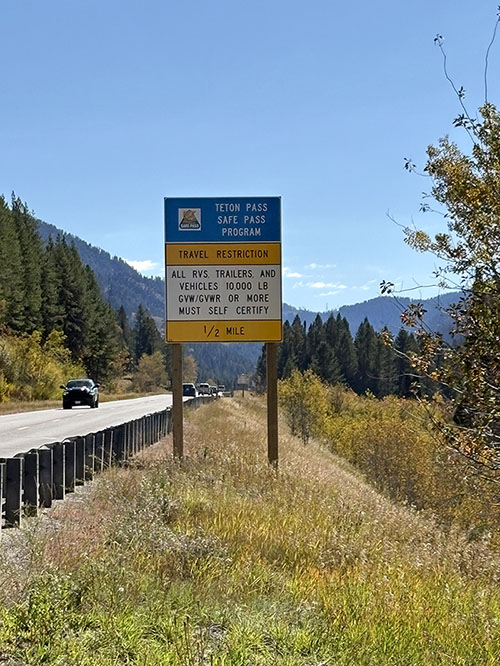 Large roadway sign along SH-33 near the Idaho and Wyoming border, detailing the need for pre-certification before traveling Teton Pass.